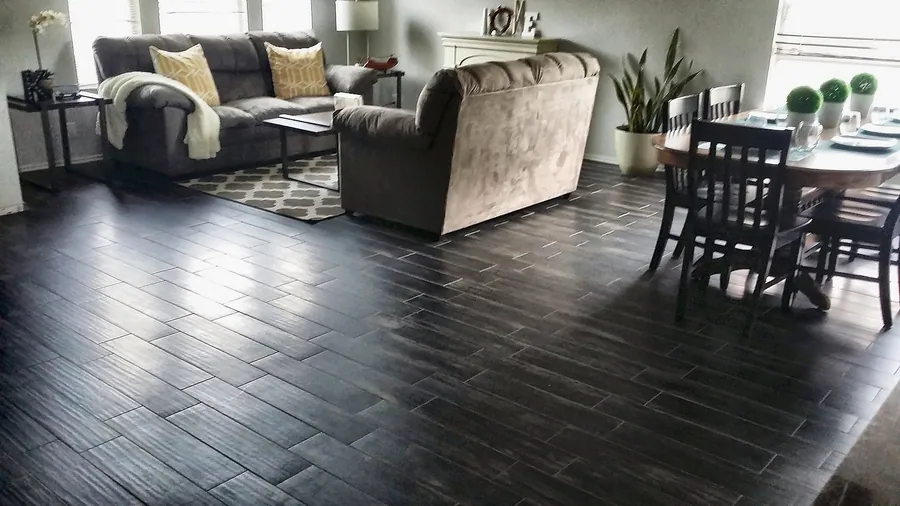Dark plank flooring connecting living and dining spaces.