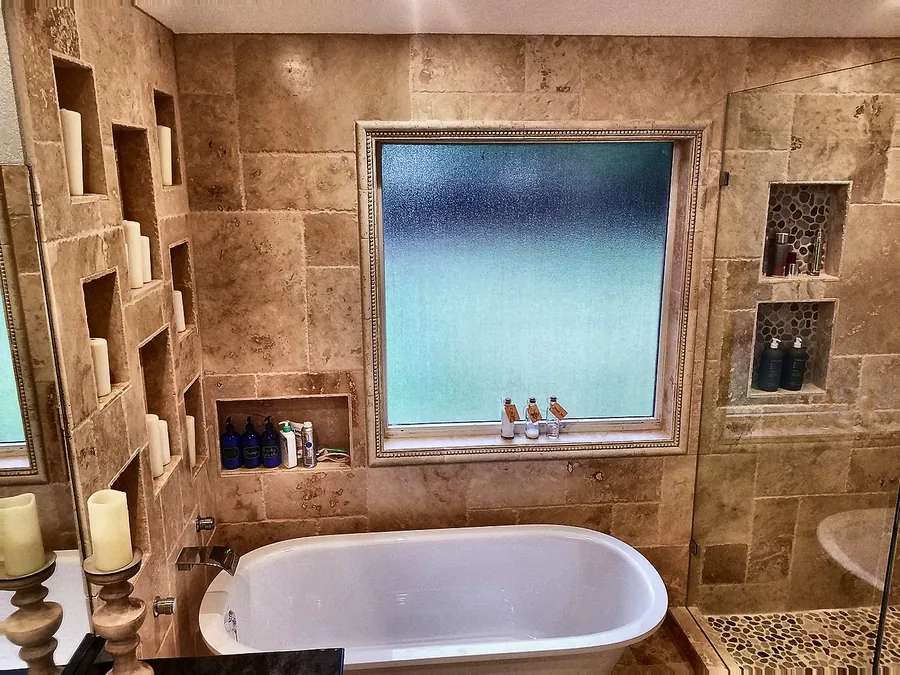 Natural stone and a freestanding bathtub with built-in niches.