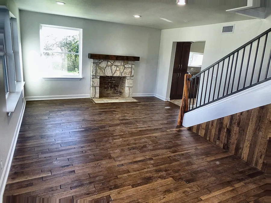 Updated living room with dark wood flooring and a stairway