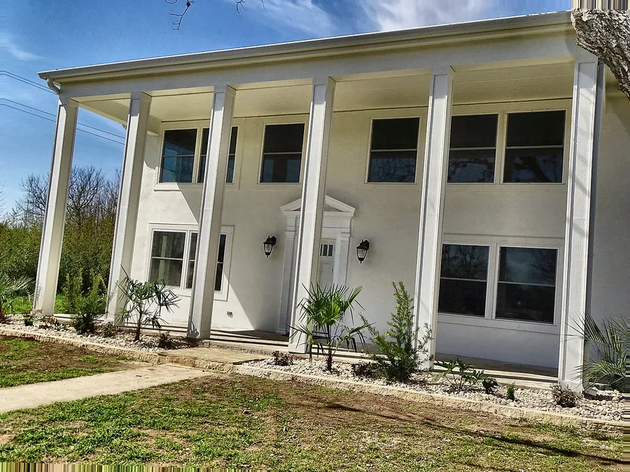 A spacious home exterior with traditional columns and finishes.