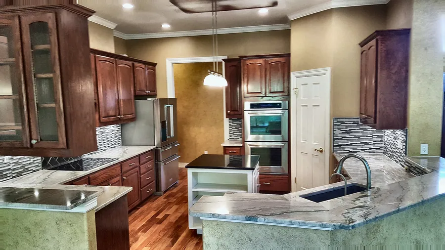 Warm wood and pale stone in an open kitchen layout.