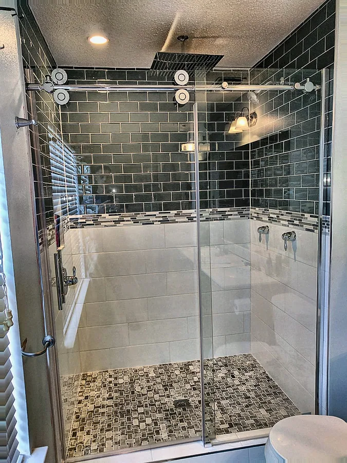 An enclosed shower with dramatic deep-toned tile.