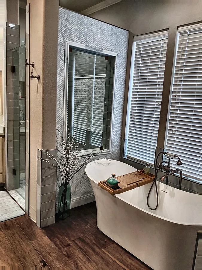 A soaking tub and tiled shower sharing a bright space.