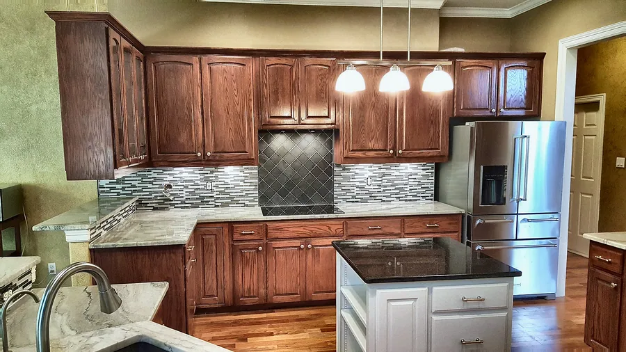 Rich cabinetry, contrasting island and tiled backsplash.