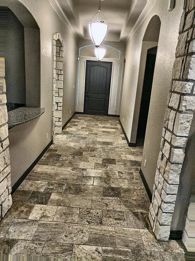 A stone-tiled interior hallway and arched doorway details.