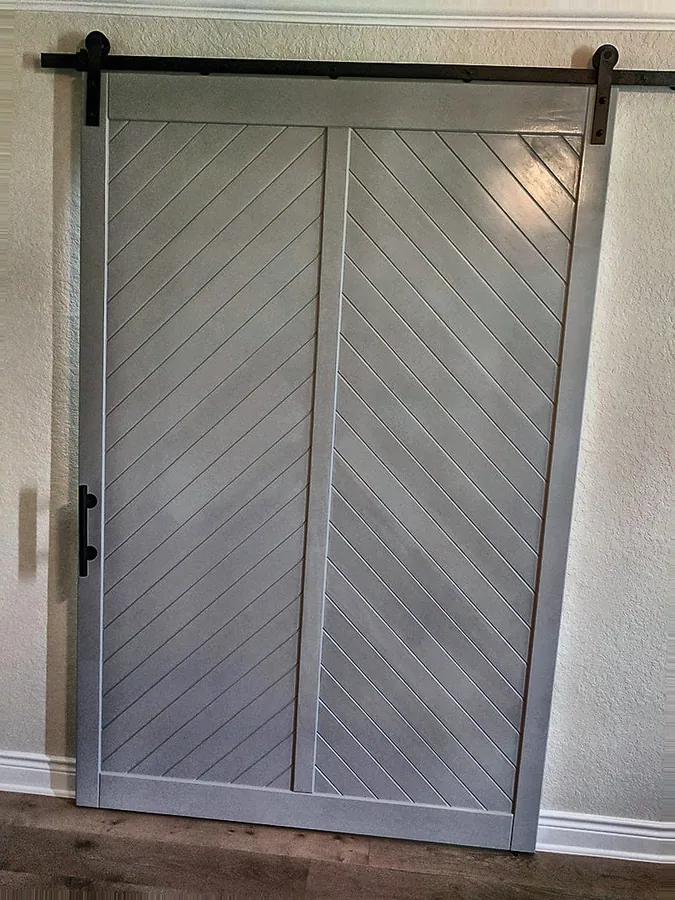 Chevron-panel doors with dark metal track hardware.