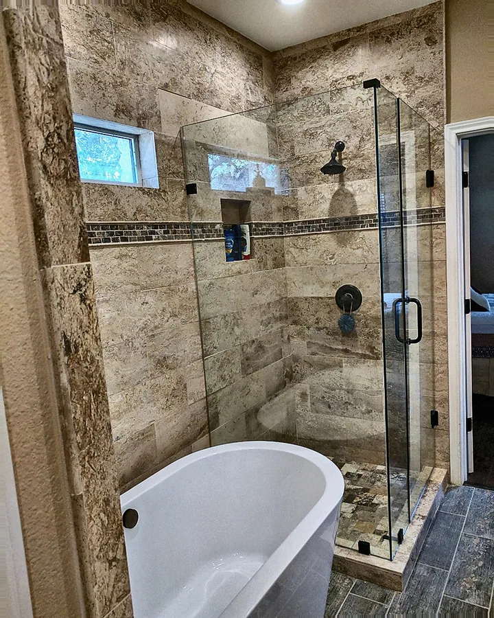 Stone tile, soaking tub and glass-enclosed shower.