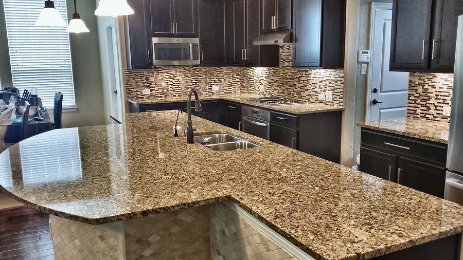 A large natural-pattern countertop with dark cabinetry.