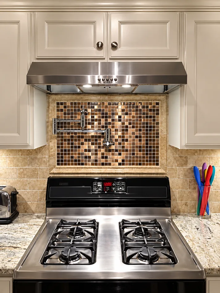 Stainless steel range and mosaic backsplash detail.