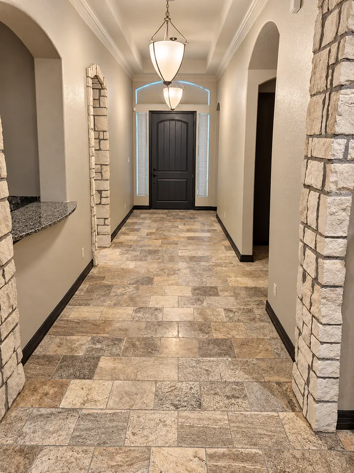 Hallway with stone accents, arched openings and patterned flooring.